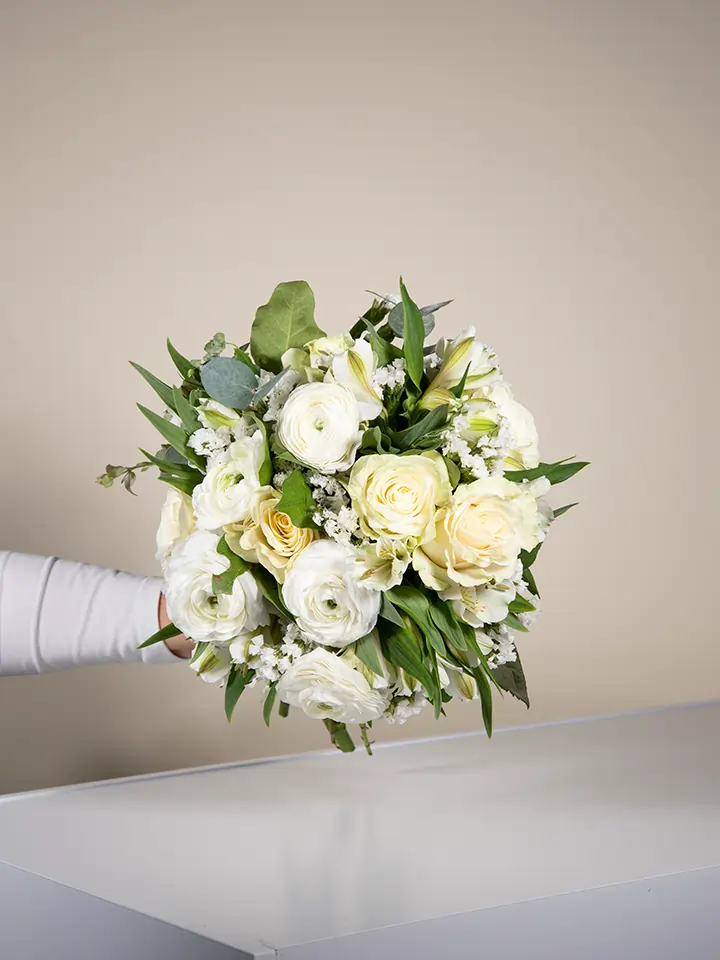 Bouquet di fiori bianchi con rose ranuncoli freesie in mano